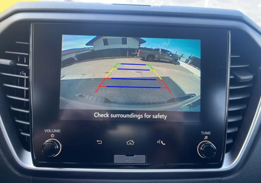 Écran tactile de la caméra de recul montrant un Isuzu D-MAX gris Kinabalu vu de l'arrière en stationnement.