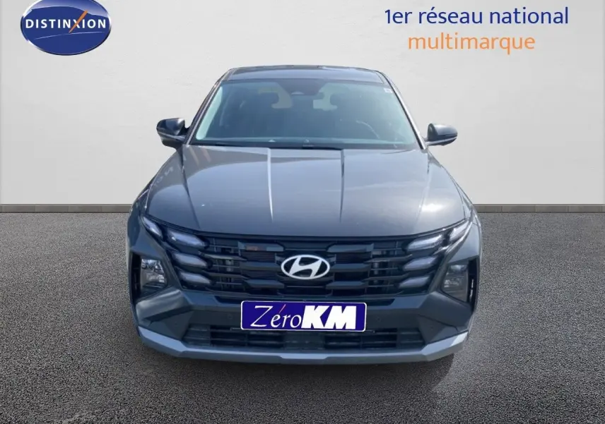 Vue frontale du Hyundai Tucson 2026 gris Ecotronic Metal avec calandre noire et logo Hyundai bien visible.