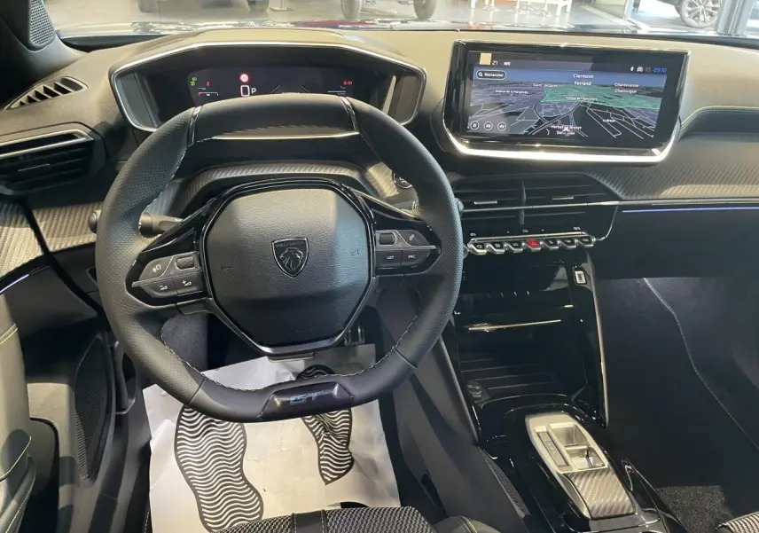 Vue intérieure centrée sur le volant GT et le tableau de bord numérique du Peugeot 2008 hybride 2026.