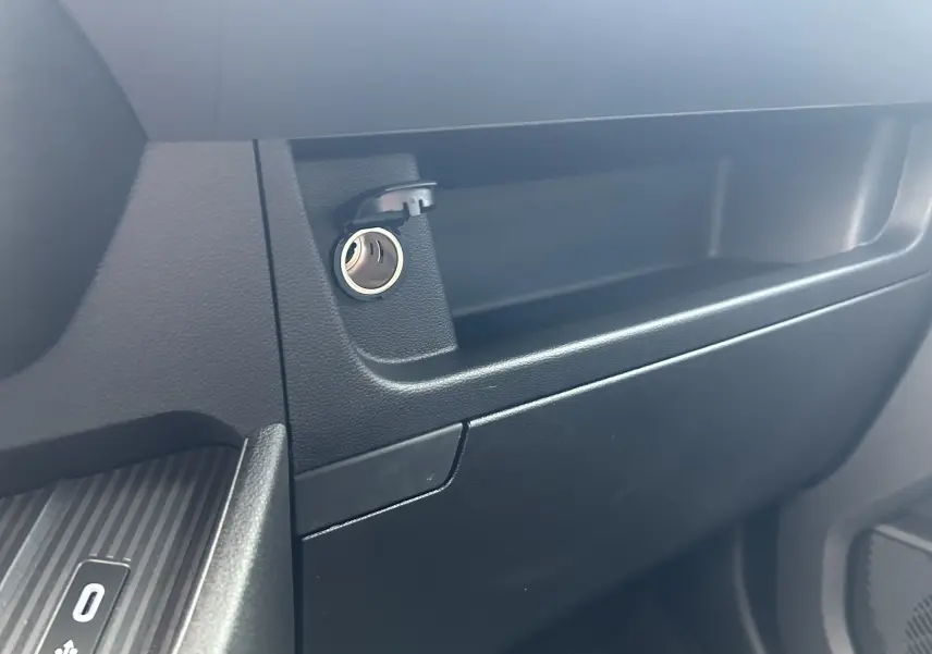 Détail de la prise 12V et du rangement côté passager intérieur du Renault Master blanc, version fourgon 2026.
