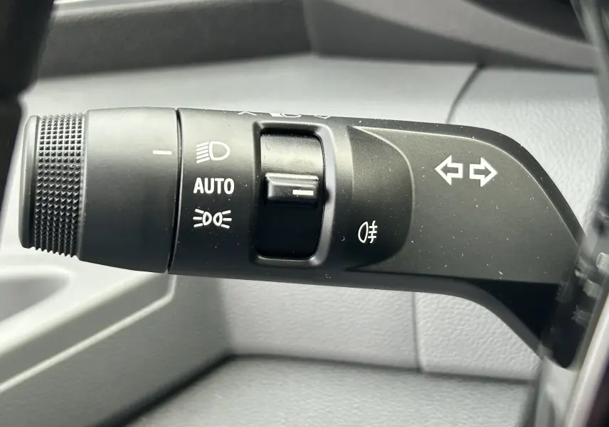 Gros plan sur la commande de clignotants et feux du Renault Master, avec marquages blancs sur fond noir.