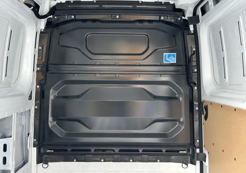 Vue intérieure du Renault Master blanc montrant la cloison de séparation noire entre cabine et espace de chargement.