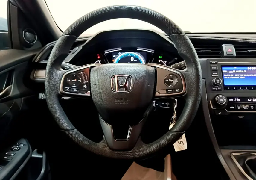 Vue intérieure centrée sur le volant cuir noir et le tableau de bord numérique de la Honda Civic 1.0 i-VTEC 2020.