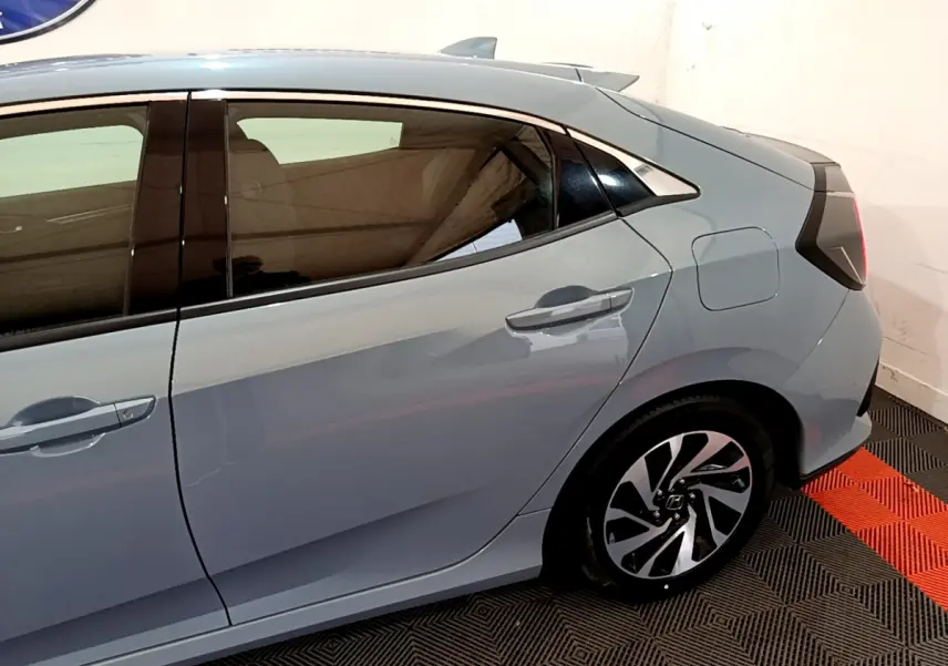 Vue latérale droite de la Honda Civic 1.0 i-VTEC Exclusive gris foncé, soulignant la porte arrière et la jante stylisée.