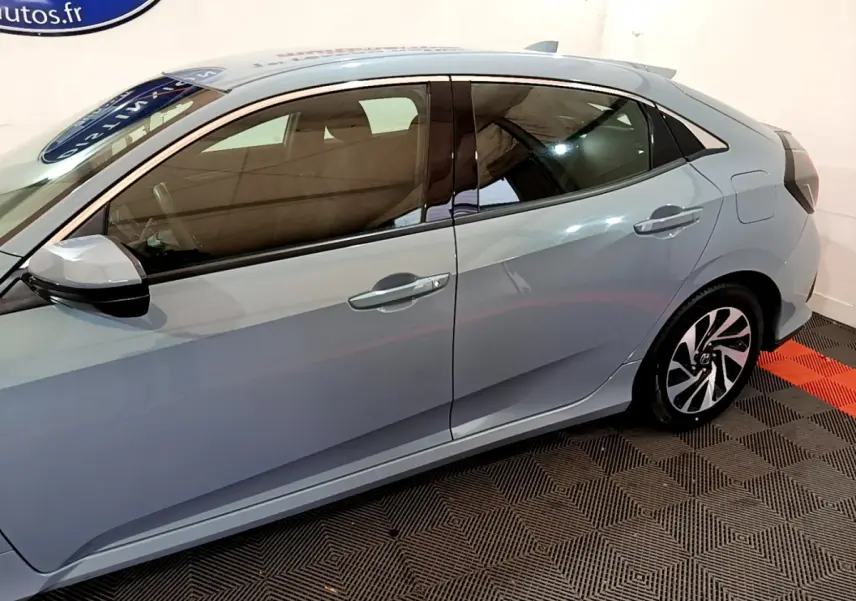 Profil côté gauche d'une Honda Civic gris foncé 2020 avec jantes alliage et rétroviseur bicolore.