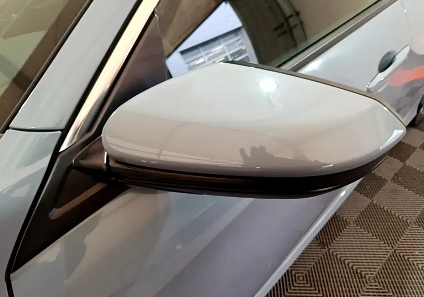 Rétroviseur côté gauche gris clair de la Honda Civic 1.0 i-VTEC Exclusive 2020, vue rapprochée sur porte gris foncé.