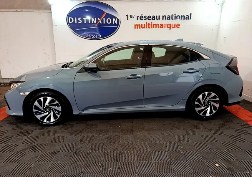 Profil côté gauche d'une Honda Civic 1.0 i-VTEC Exclusive gris foncé, avec jantes alliage et vitres teintées.