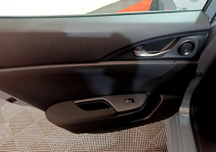 Détail de la porte côté gauche intérieure de la Honda Civic 1.0 i-VTEC Exclusive gris foncé avec poignée et haut-parleur intégrés.