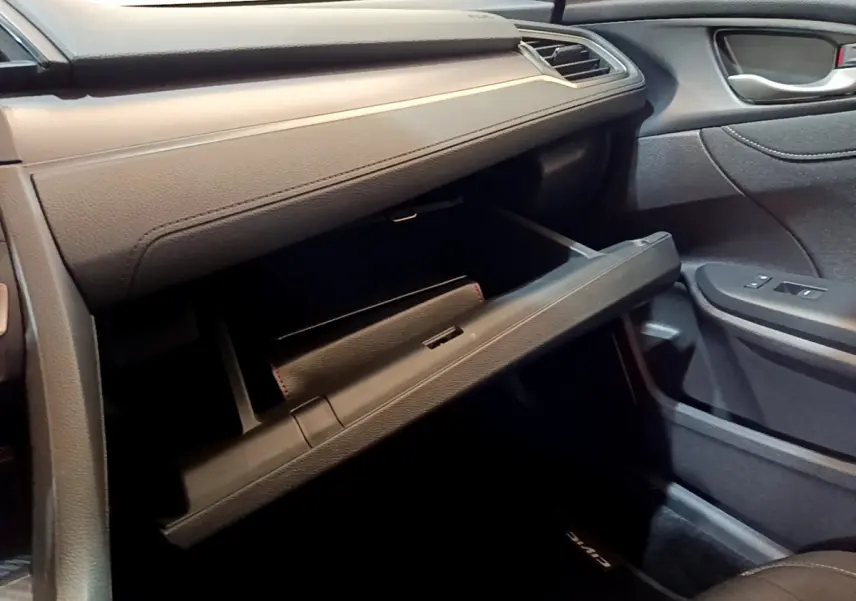 Gros plan sur la boîte à gants ouverte côté passager de la Honda Civic 1.0 i-VTEC Exclusive 2020 gris foncé.