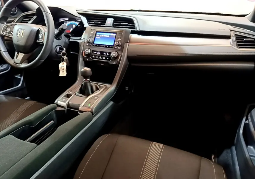 Intérieur de la Honda Civic 1.0 i-VTEC Exclusive 2020, vue côté conducteur sur tableau de bord et console centrale noire.