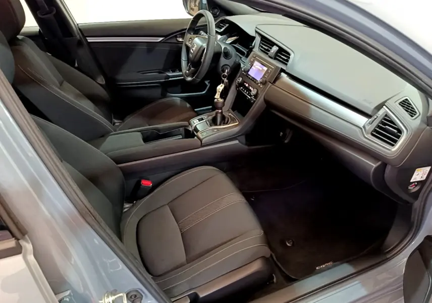 Intérieur avant droit de la Honda Civic 1.0 i-VTEC Exclusive 2020, sièges noirs et tableau de bord moderne.