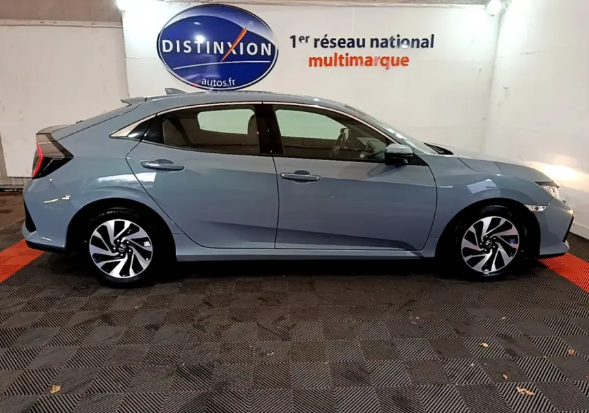 Profil côté droit d'une Honda Civic 1.0 i-VTEC Exclusive gris foncé, avec jantes alliage et feux arrière distinctifs.
