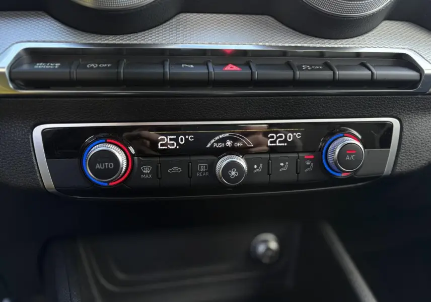 Vue rapprochée de la console centrale de l’Audi Q2 30 TDI S-Line 2025, affichant la climatisation automatique bi-zone.