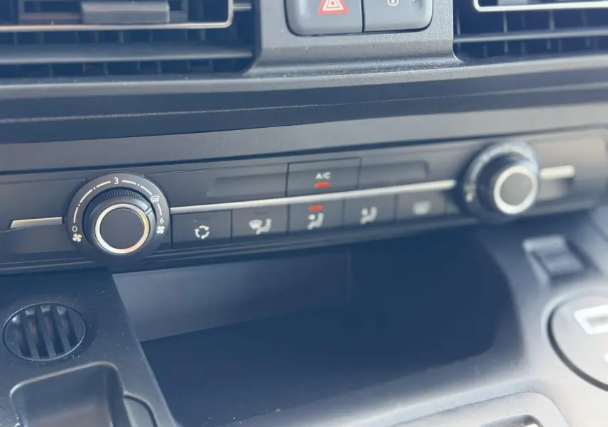 Détail de la console centrale noire du Citroën Berlingo 2025, avec commandes de climatisation et ventilation.