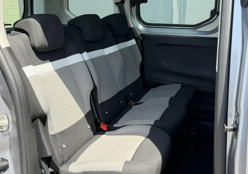 Vue intérieure côté droit sur la banquette arrière gris clair et foncé du Citroën Berlingo ë-136 2025 avec porte coulissante ouverte.