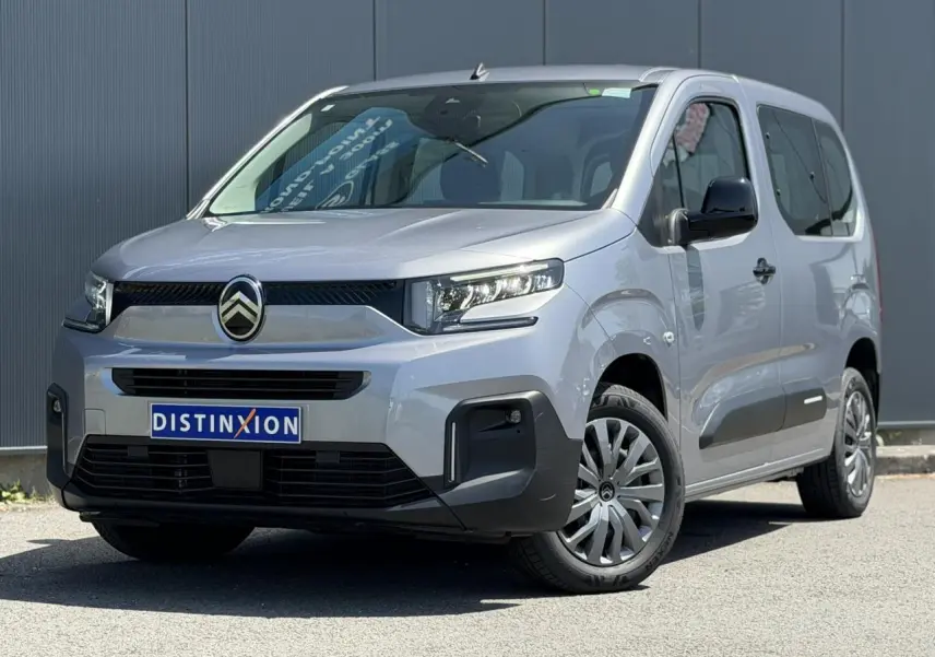 Vue 3/4 avant droit du Citroën Berlingo ë-136 gris Artense avec calandre noire et jantes tôles 16 pouces.