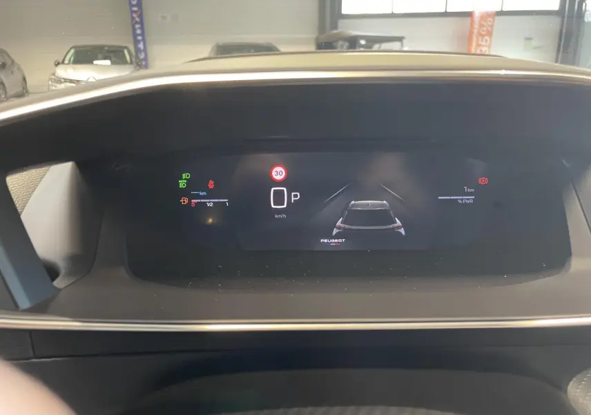 Vue rapprochée du tableau de bord numérique du Peugeot 2008 Hybrid 2026 affichant la vitesse et l'état du véhicule.