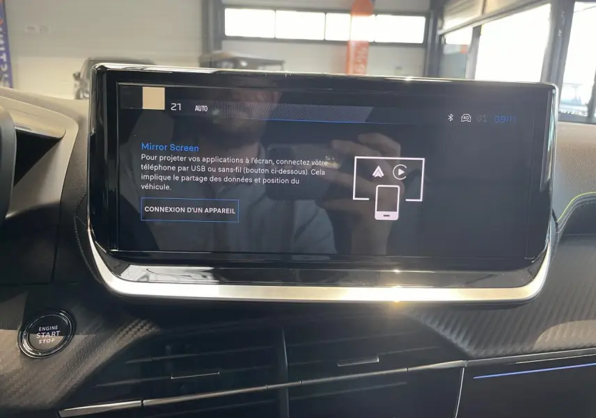 Écran tactile central du Peugeot 2008 Hybrid 2026, vue rapprochée du tableau de bord avec bouton start/stop.