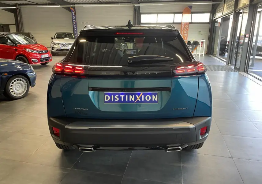 Vue arrière d'un Peugeot 2008 bleu métallisé avec feux arrière LED 3 griffes et double sortie d'échappement chromée.