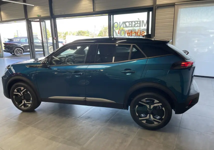 Peugeot 2008 hybride bleu vue de profil côté gauche en intérieur, avec toit noir et jantes distinctives.
