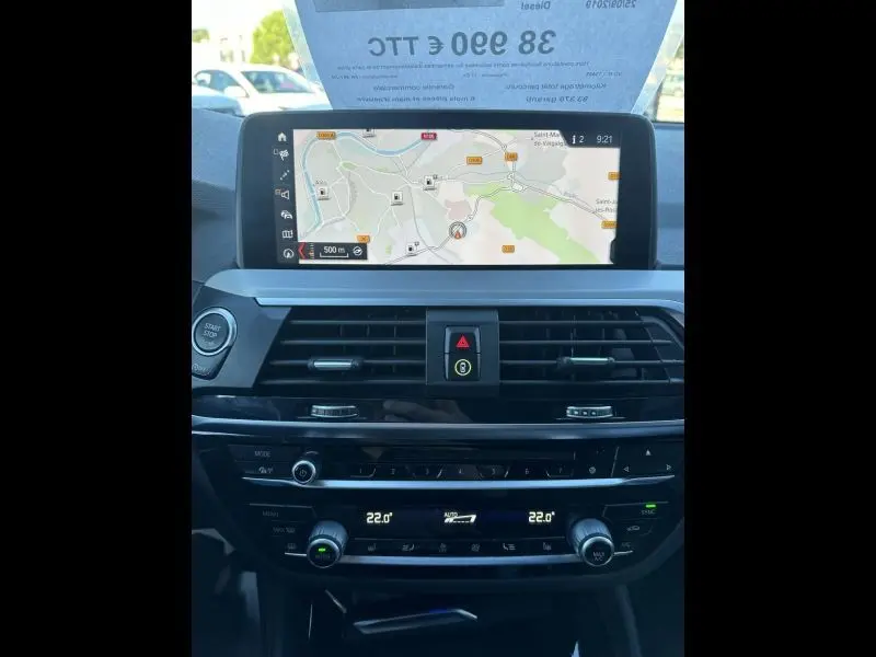 Tableau de bord du BMW X4 X Line 2019 avec écran GPS, commandes climatisation et bouton start/stop visibles.