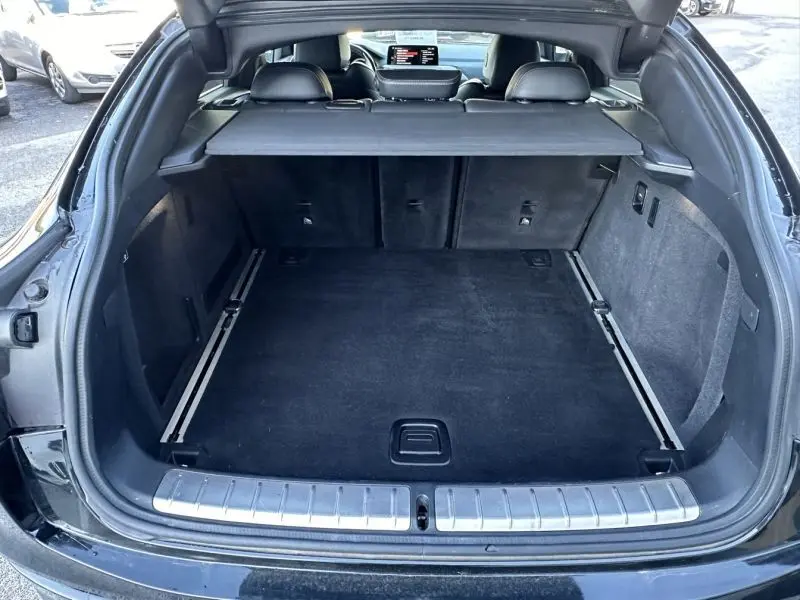 Coffre ouvert en vue arrière d’un BMW X4 gris foncé 2019 X Drive 190 CV X-Line, intérieur noir et tablette de séparation.