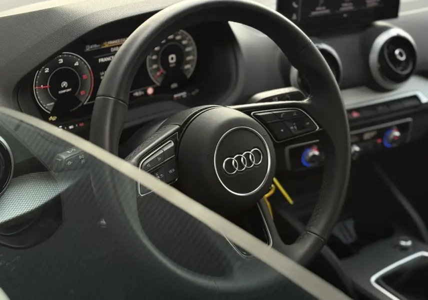 Vue rapprochée du volant multifonction en cuir et du tableau de bord numérique de l'Audi Q2 30 TDI 116 S-Line.