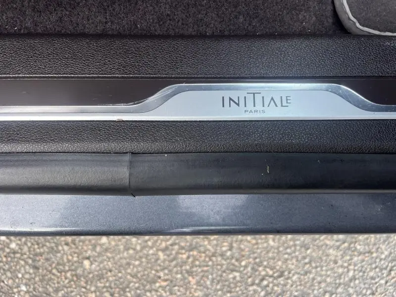 Gros plan sur la plaque de seuil de porte "Initiale Paris" du Renault Espace gris Cassiopée, finition haut de gamme.