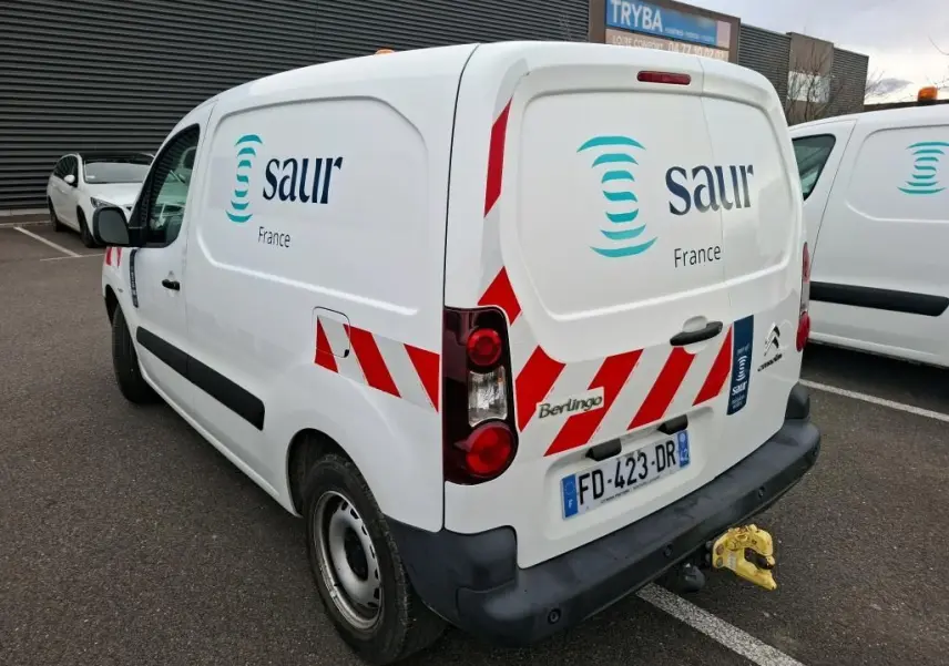 Vue 3/4 arrière droite d'un Citroën Berlingo blanc utilitaire avec marquage rouge, logo Saur France et attelage jaune.