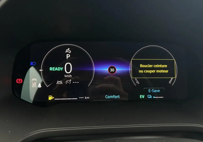 Tableau de bord numérique du Renault Captur 2026 affichant la vitesse à 0 km/h et mode Confort, avec alertes de sécurité visibles.
