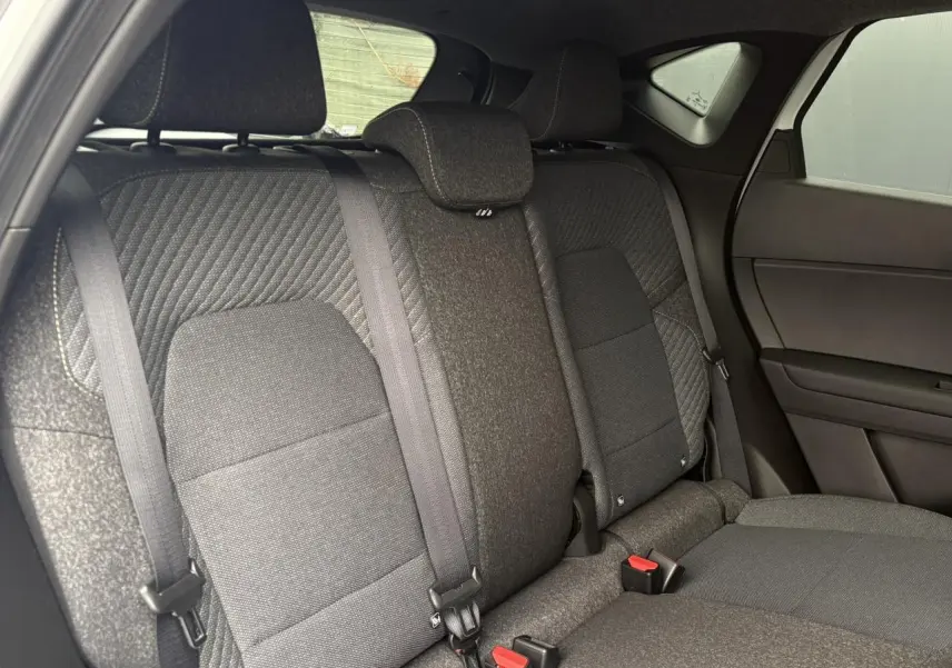 Vue intérieure des sièges arrière en tissu gris foncé du Renault Captur 2026, côté droit, avec ceintures de sécurité visibles.