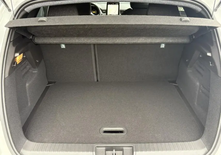 Coffre ouvert vu de l'arrière du Renault Captur blanc nacré, montrant un espace de chargement propre et bien fini.
