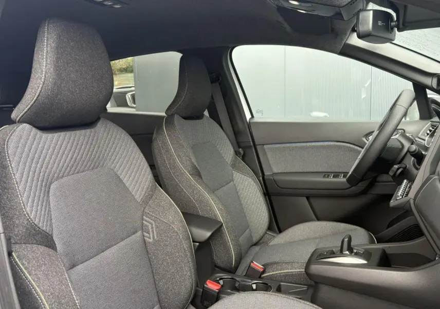 Vue intérieure côté droit du Renault Captur 2026, sièges tissu gris avec surpiqûres contrastantes et console centrale noire.