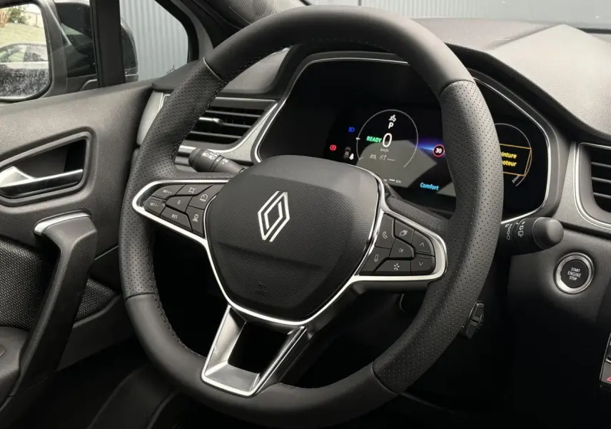 Intérieur du Renault Captur 2026 vu côté conducteur, volant noir avec commandes intégrées et tableau de bord numérique.