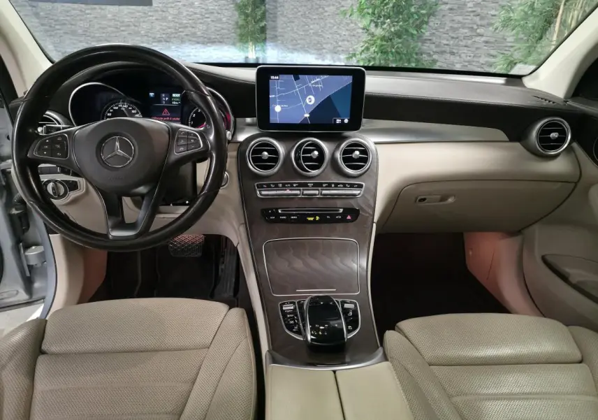 Vue intérieure avant du Mercedes GLC 350 e 2017, tableau de bord beige avec inserts en frêne et écran central tactile.