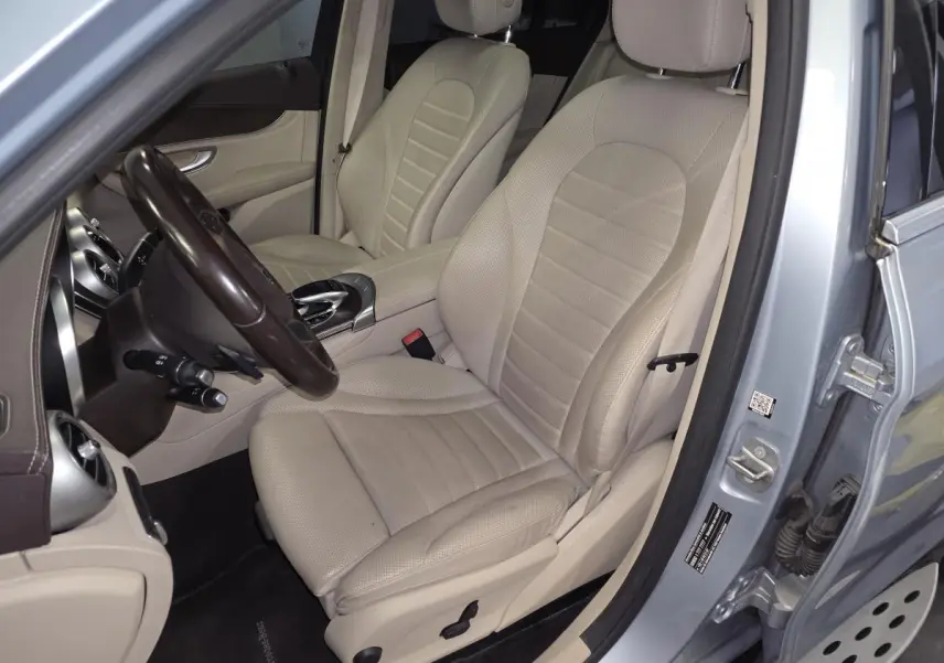 Vue intérieure côté conducteur du Mercedes GLC 350 e gris, sièges cuir beige et tableau de bord marron.