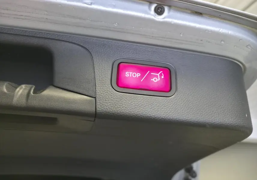 Bouton rouge STOP pour fermeture automatique du hayon sur le coffre d'un Mercedes GLC gris hybride rechargeable.
