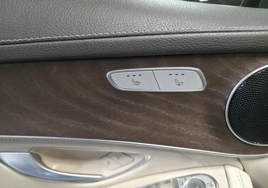 Détail de la porte côté gauche du Mercedes GLC 350 e gris, avec inserts bois et commandes sièges chauffants.