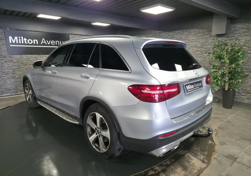 Mercedes GLC 350 e gris métallisé vu en 3/4 arrière droit avec attelage et jantes alliage 19 pouces.
