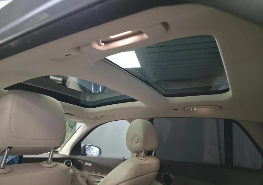 Vue intérieure du toit ouvrant panoramique et des sièges avant en cuir beige du Mercedes GLC 350 e gris de 2017.