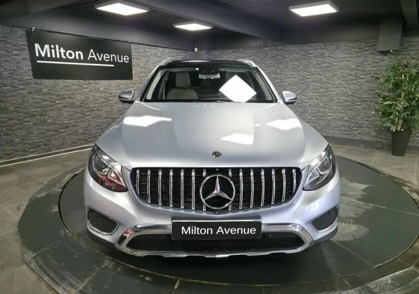 Vue avant d'un Mercedes GLC 350 e gris métallisé avec calandre verticale et logo étoile bien visible.