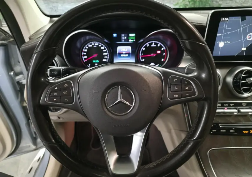 Vue intérieure centrée sur le volant cuir noir et le combiné d'instruments du Mercedes GLC 350 e hybride 2017.