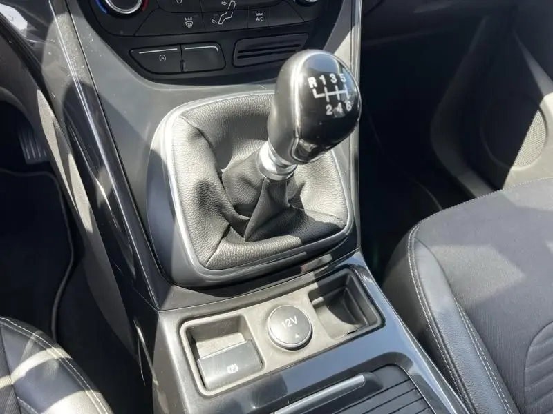 Gros plan sur le levier de vitesses manuel du Ford Kuga 2018 bleu foncé, avec console centrale et bouton 12V visibles.