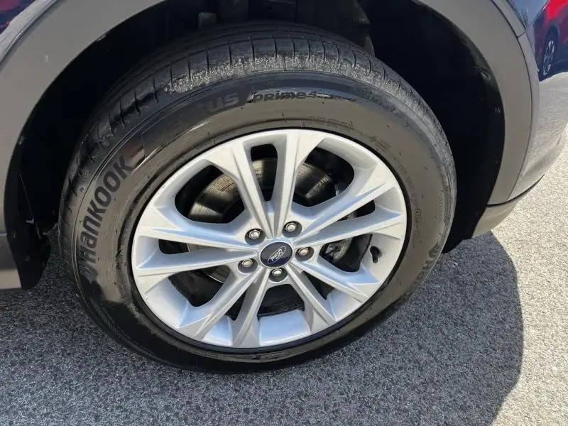 Gros plan sur la roue avant droite du Ford Kuga bleu foncé 2018, mettant en valeur la jante alliage et le pneu Hankook.