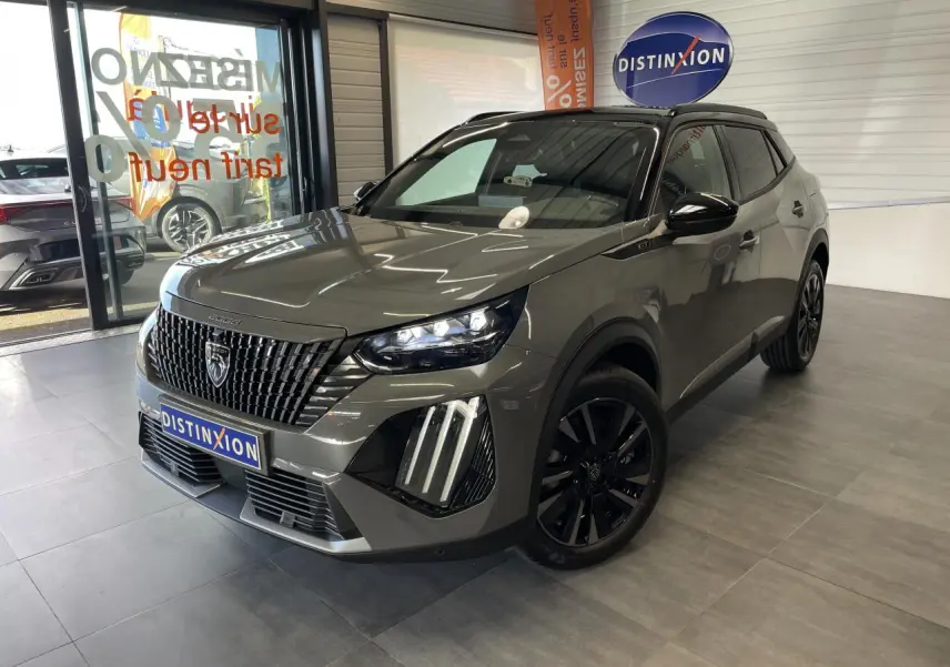 Peugeot 2008 gris en 3/4 avant droit, avec calandre noire distinctive et jantes alliage noires, en showroom.