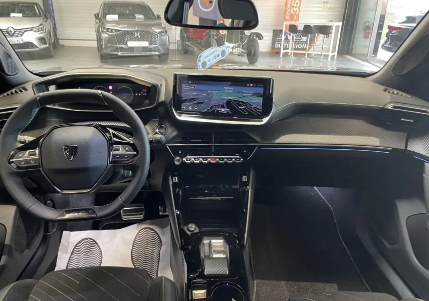Vue intérieure avant du Peugeot 2008 gris hybride, mettant en valeur le tableau de bord numérique et l’écran tactile central.