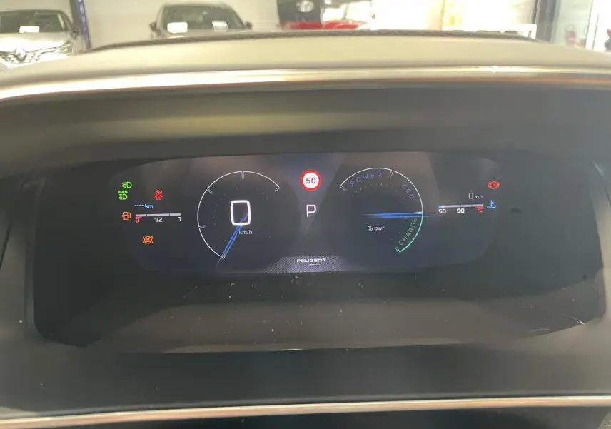 Vue rapprochée du tableau de bord numérique du Peugeot 2008 gris 1.2i Hybrid 2026, affichant la vitesse à 0 km/h.