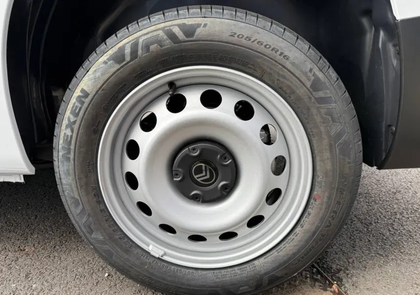 Gros plan sur la roue avant droite en acier gris du Citroën Berlingo Fourgon blanc Icy.