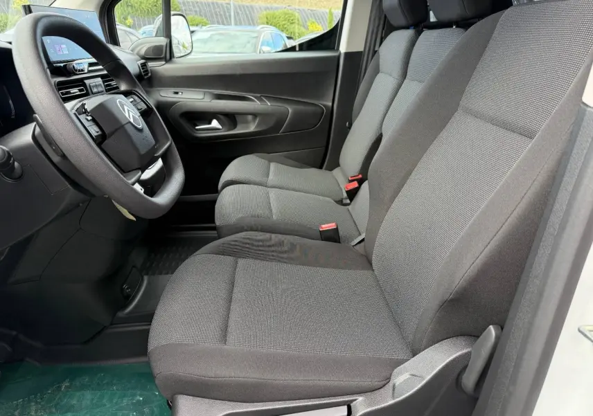 Vue intérieure côté conducteur du Citroën Berlingo Fourgon XL Diesel 130ch 2026 avec sièges tissu gris et volant multifonction.
