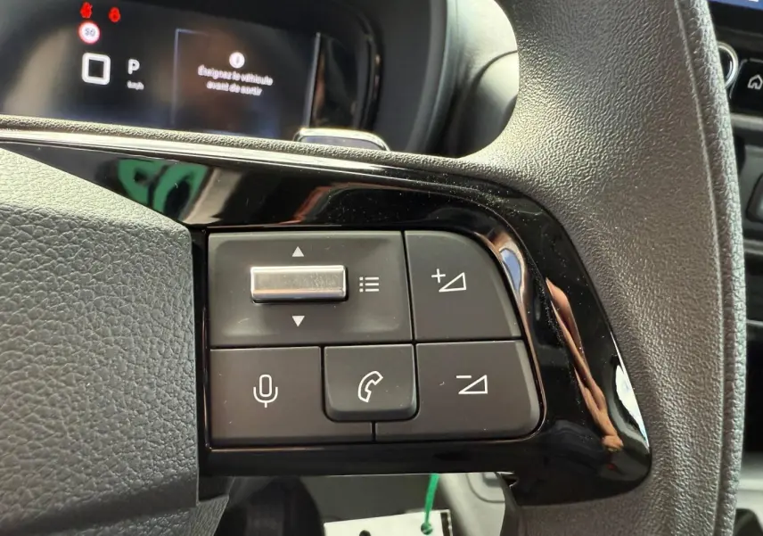 Gros plan sur les commandes multifonctions du volant du Citroën Berlingo Fourgon 2026, finition noire brillante.